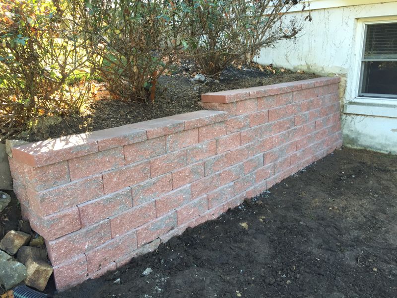 professionally installed red and gray concrete block retaining wall